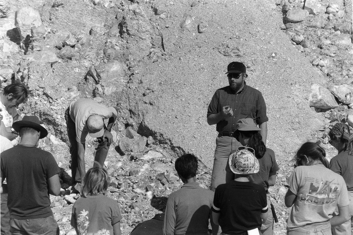 Gordon Brown speaks to a group of students examining rock formations.