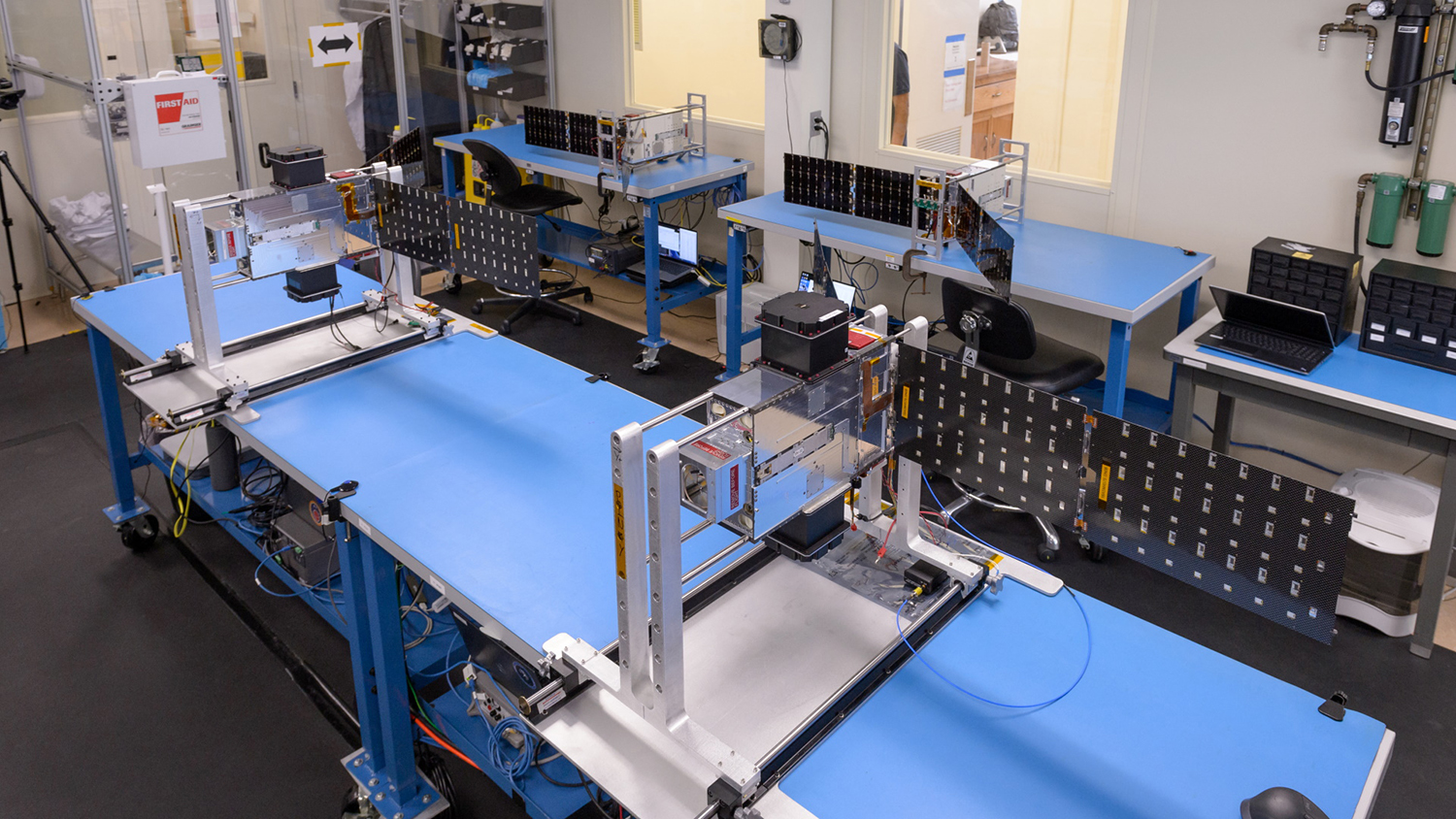 Pictured are the swarm spacecraft modules affixed on top of workbenches at NASA.