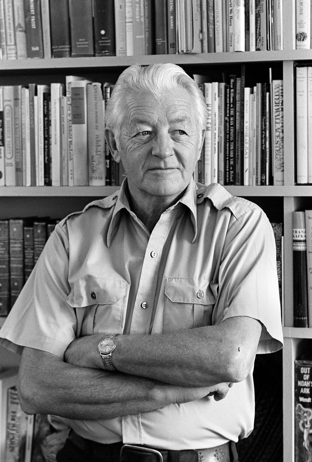 A black and white profile photo of Wallace Stegner in his office.