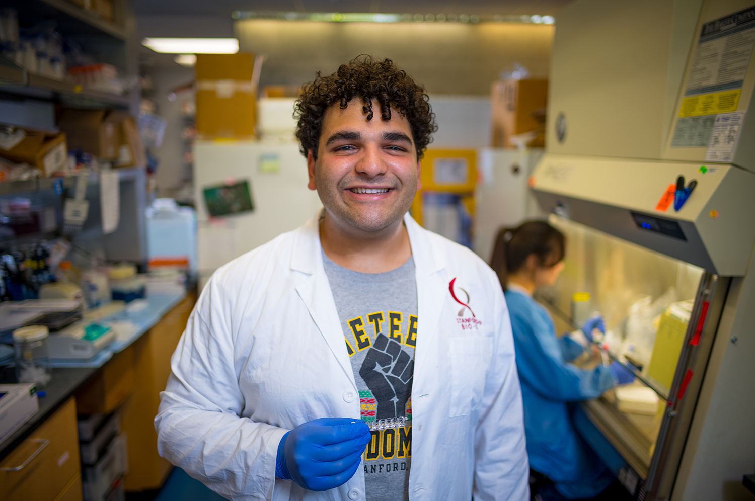 Image of Nicholas Neoman holding his microplate strip to test cytokine levels.