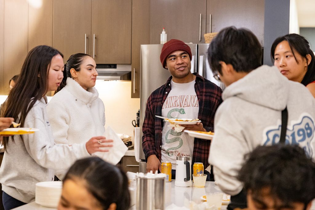 Students gather in a dorm dinning area to enjoy snacks during a Civic Salon discussion.
