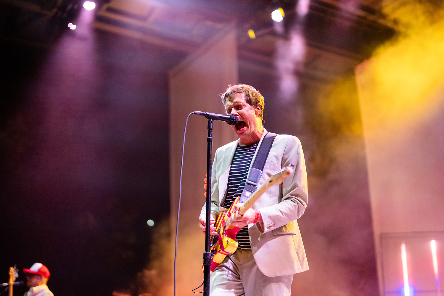 Guitarist from band OK Go sings and plays on stage.