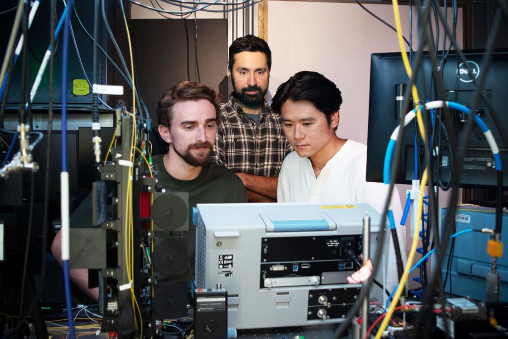 Portrait of the three researchers surrounded by instrumentation.