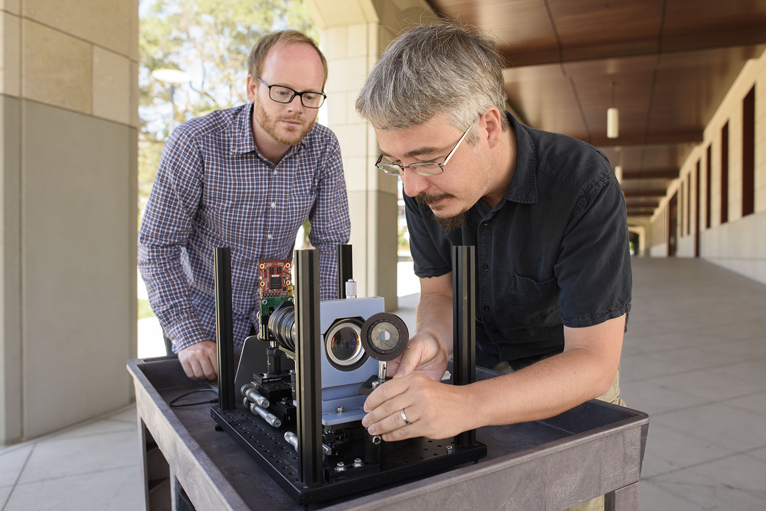 Assistant prof. Gordon Wetzstein, left, and postdoctoral scholar Donald Dansereau with a prototype of the monocentric camera that captured the first single-lens panoramic light fields.