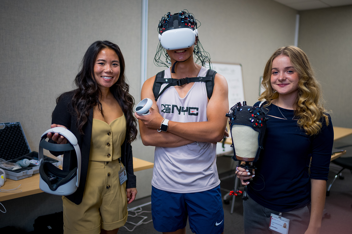 Image of three students posing with various VR headsets.