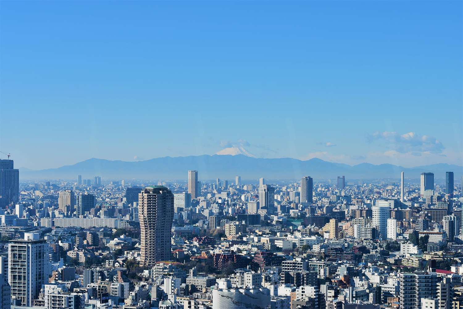 Photo of Mt. Fuji in the background and an aerial view of Tokyo, Japan, taken from the Mori Art Museum.