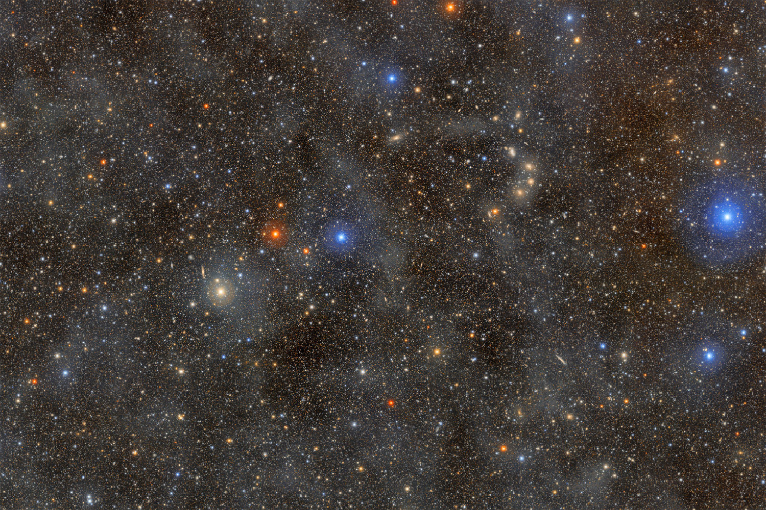 A vast expanse of space filled with numerous stars and a mix of colors against a dark background.