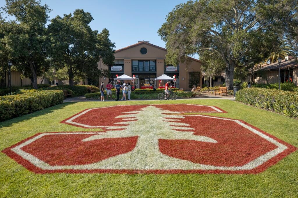 Shows a typical student residence with the Stanford logo painted on the front lawn.