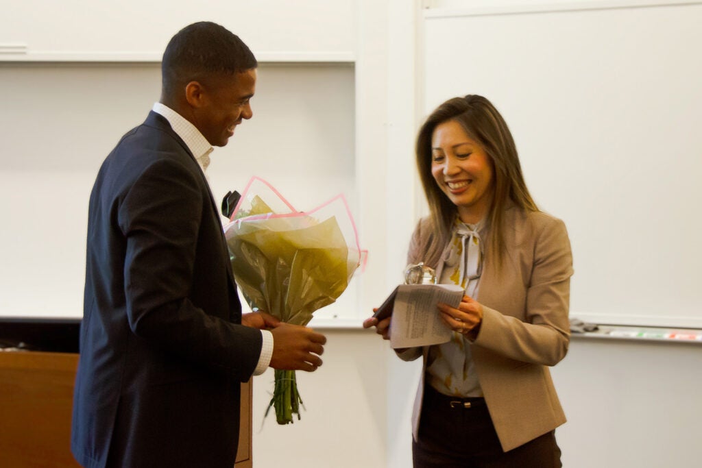 An MBA student hands an award to GSB associate professor of marketing Szu-chi Huang.