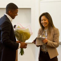 An MBA student hands an award to GSB associate professor of marketing Szu-chi Huang.
