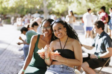 Two students holding snow cones.