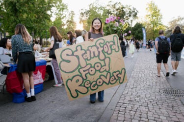 Student carrying a Stanford Food Recovery sign