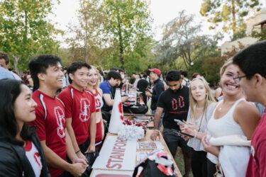 Members of Stanford cheer team speaking to possible recruits