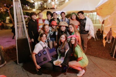 Group photo of a dozen students in costume at Tresidder