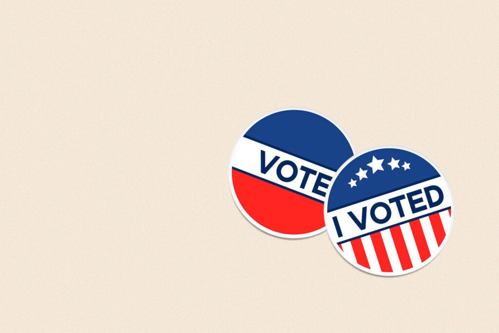 "I voted" pins on a plain beige background.
