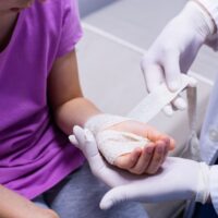 medical professional bandages child's hand