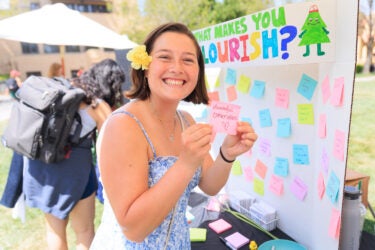 Student holding up a stickie note.