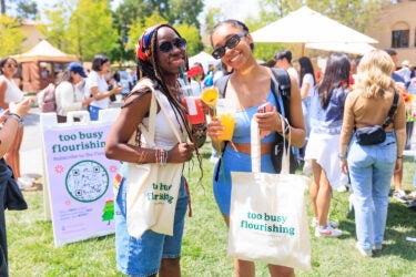 Two students with tote bags.