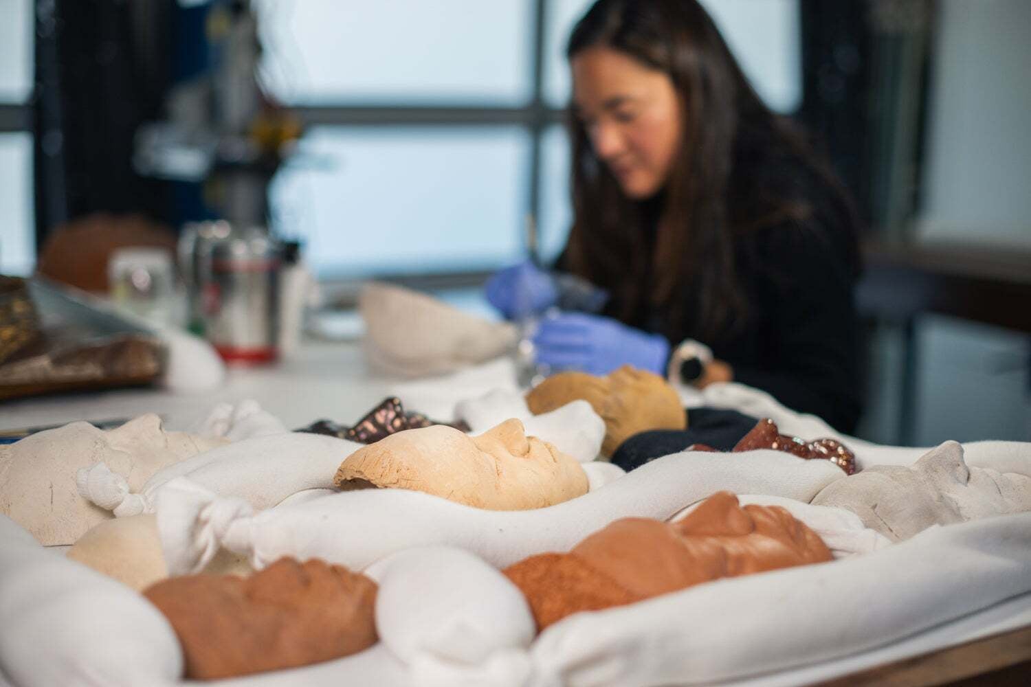Conservator Catherine Coueignoux inspects and processes each mask prior to public display.