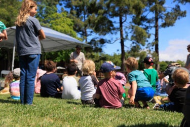 Children seated at the zookeeper's tent.