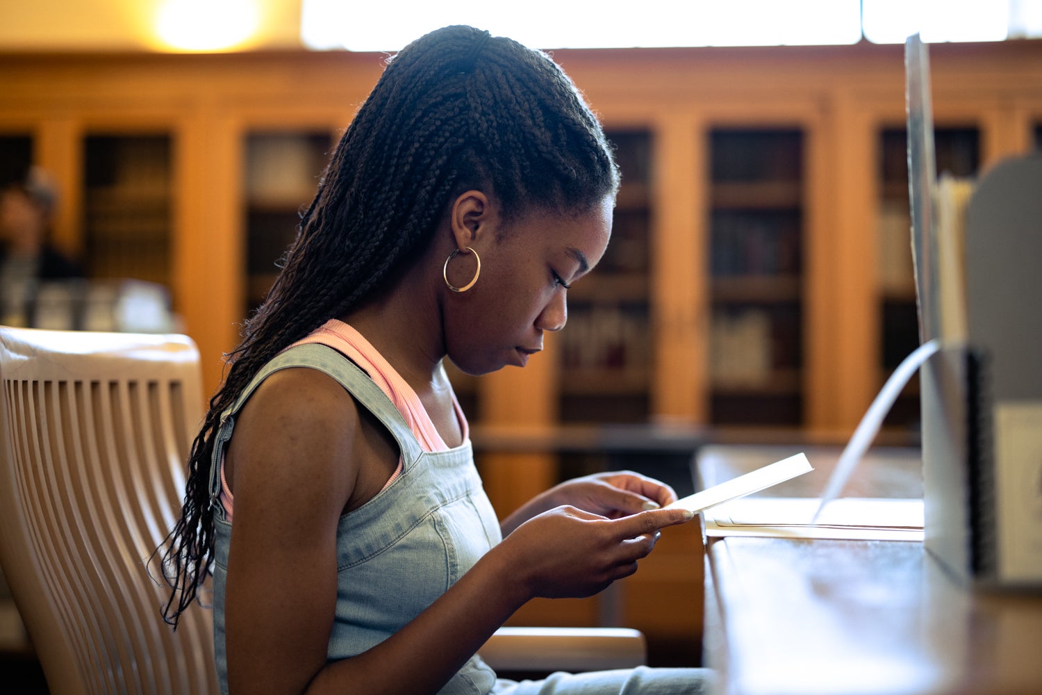 Kene Nzelu, a junior majoring in history, pores over items from the Stanford University Archives for her final project that looks at the role of women in Stanford’s history.