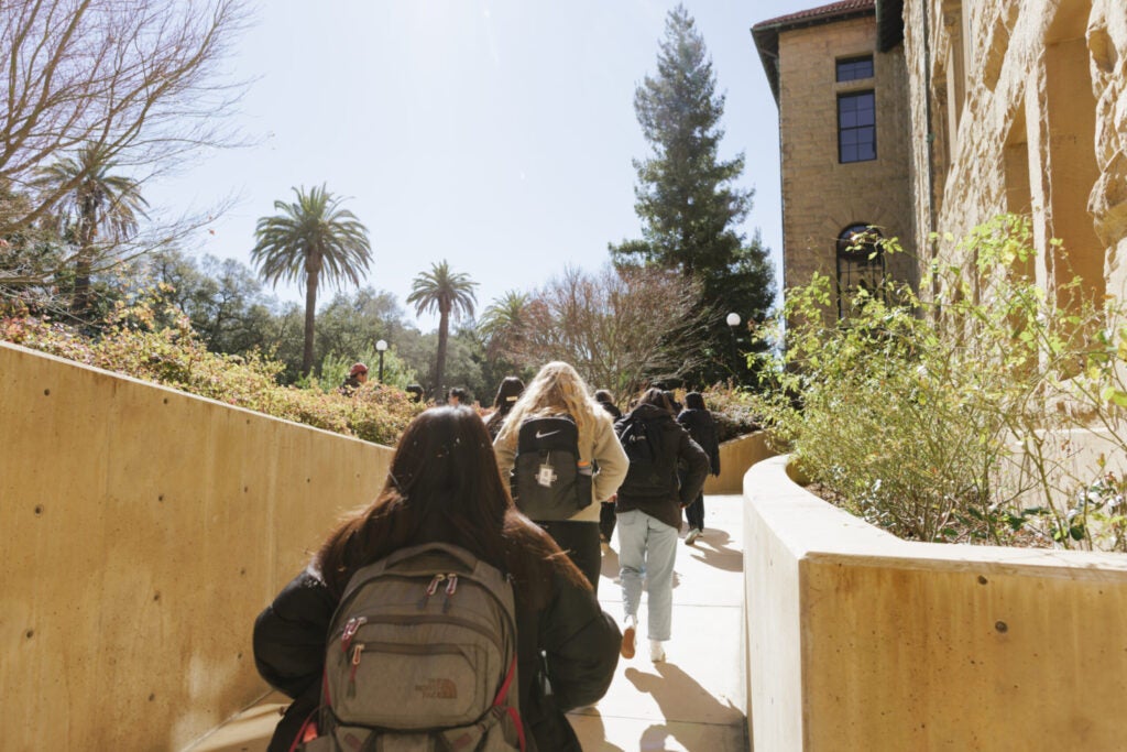 students wearing backpacks exit a campus building
