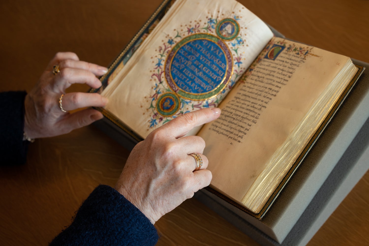 Elaine Treharne points to a page in an illustrated manuscript.