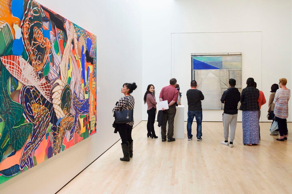 A group of visitors take a docent-led tour through the modern art gallery at the Cantor Arts Center.