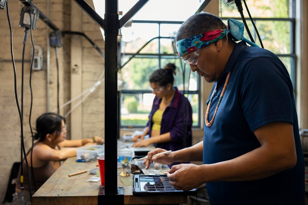 Navajo artist Robert Blackhat Jr. and students at the workbench.