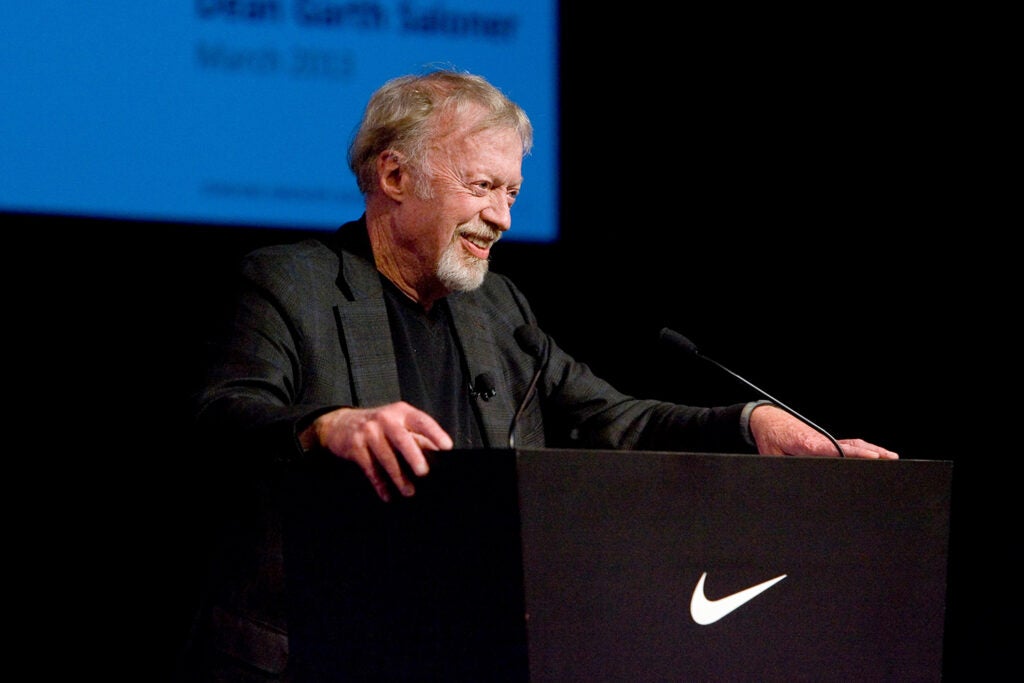 Phil Knight at lectern with Nike swoosh