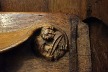 A musician bows a stringed instrument in this wood carving in Winchester Cathedral in the south of England.
