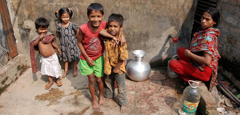 Woman and children at water standpipe in Dhaka
