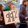 woman at protest holding a sign saying 'I am the 99 percent' / miker/Shutterstock