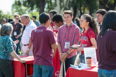 students chatting at a resource fair information table