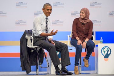 Barack Obama gesturing like he is holding a phone while talking with Mai Medhat