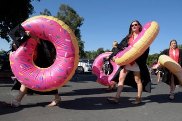 The women's swim team wear giant inflatable doughnut life preservers to the Wacky Walk