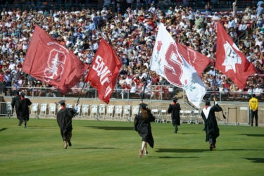 The Axe Committee flag bearers sprint onto the field