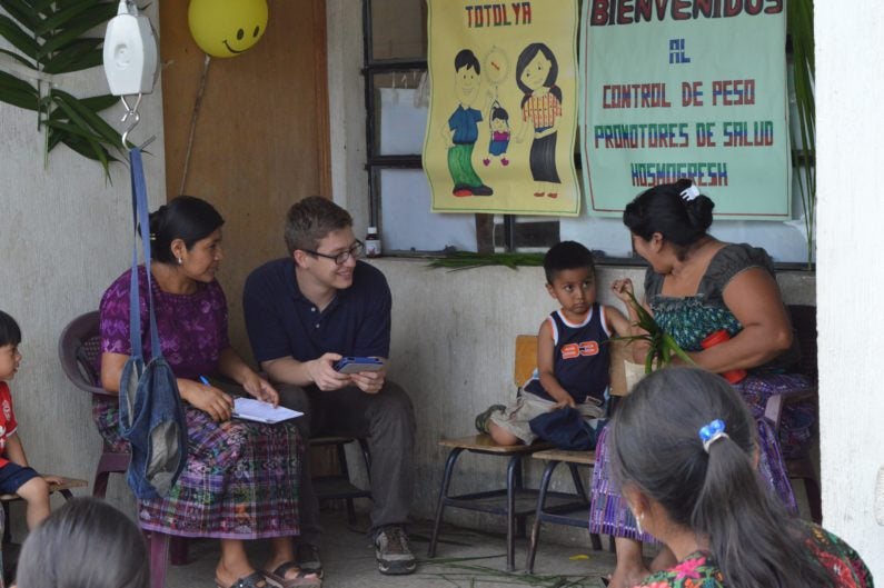 Research assistant Alejandro Chavez works with mothers and health promoter in a health center in Guatemala
