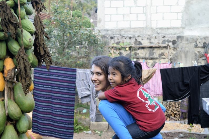 First-year medical student Tori Bawel plans a career improving health in areas of poverty. Fátima shows off her Stanford gear as she gets a ride from Bawel. Because of contributions from FSI, children like Fátima are getting the nutritional supplements they need. 