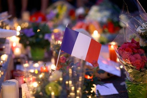 French flag amid candles and flowers