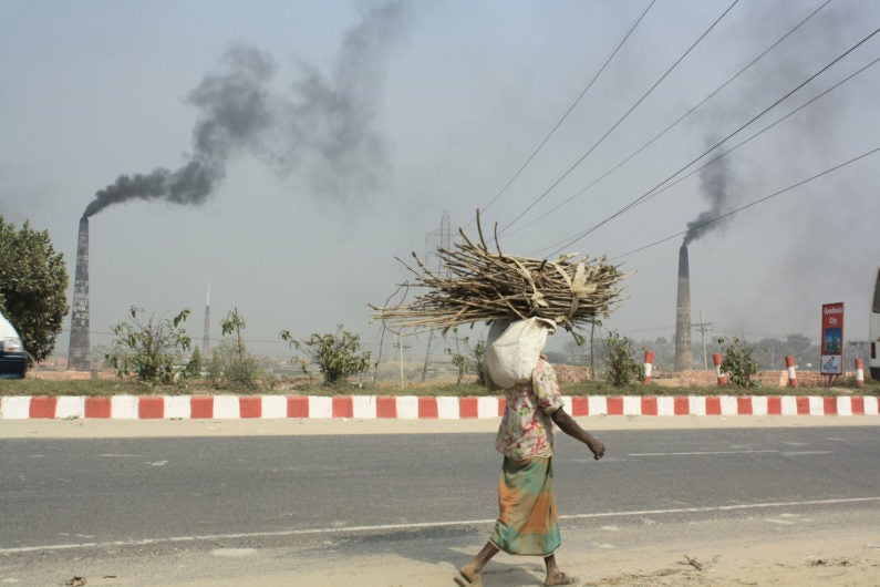 Woman walking past smoke in Bangladesh