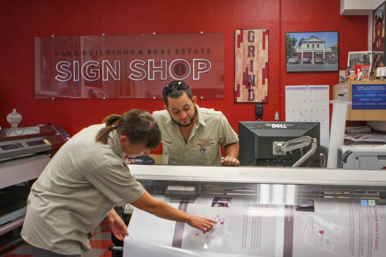 Suzy Huizinga and Jorge Granados of the Sign Shop print out signs for the new interpretive kiosks.