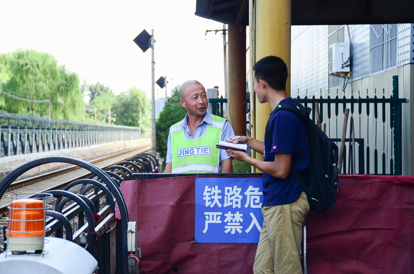 Student conducts fieldwork in Beijing by interviewing train station guard.