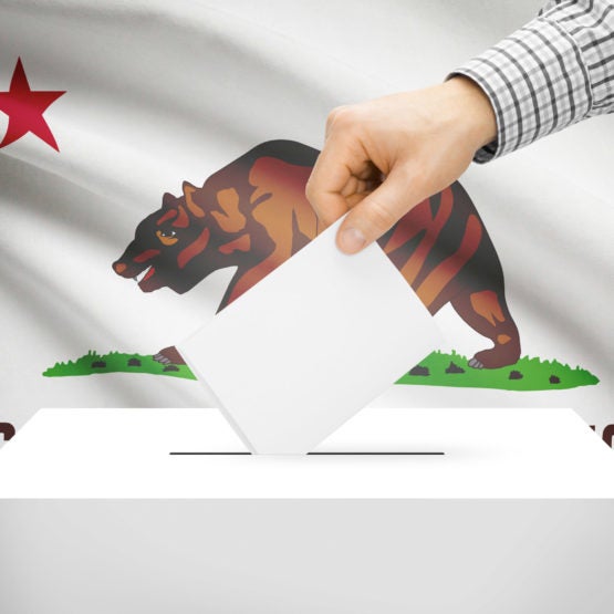 Ballot box with California state flag in the background.