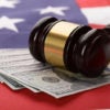 Close-up Of Wooden Brown Gavel On Usa Dollar Banknotes And American Flag