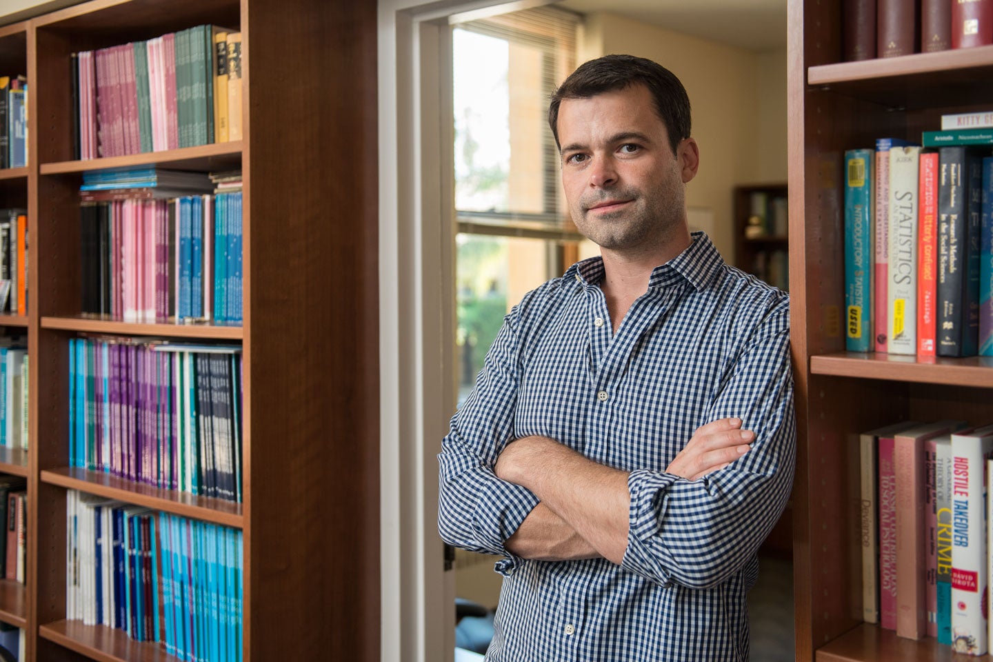 Robb Willer standing in front of a bookcase in his office