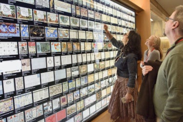 family members looking at a wall of maps