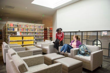 students chatting in a study area near the skylight in Li & Ma Science Library