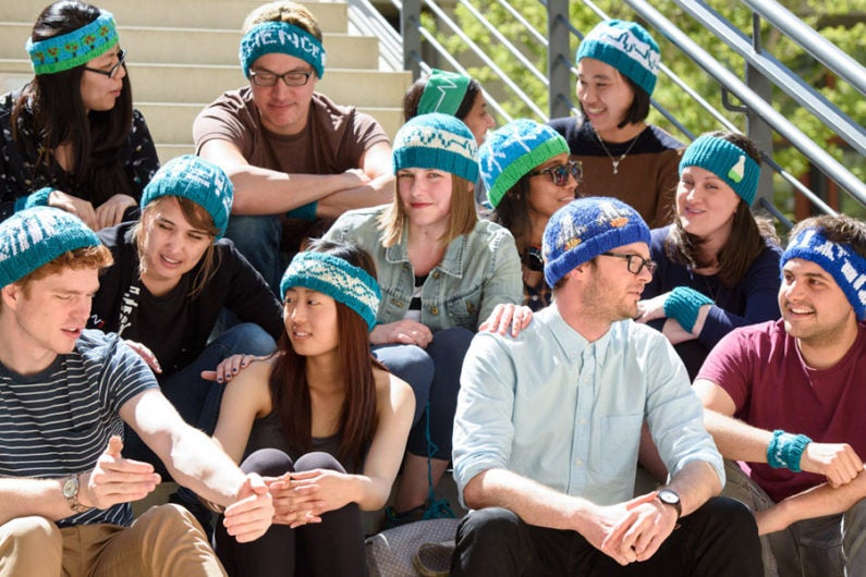 Heidi Arjes, a postdoctoral scholar in bioengineering, center, has created knit hat designs for the April 22 March for Science. Designs feature a DNA double helix, lab glassware, a circuit with a battery and three resistors, a space shuttle, wind turbines and others.