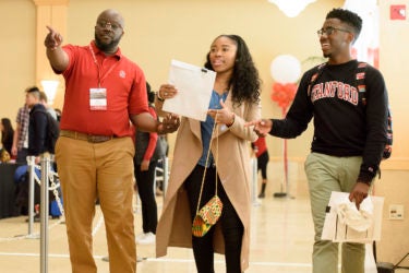 Assistant Dean of Diversity Femi Ogundele assists N’Naserri Carew-Johnson and Jonathan Johnson, admits who both graduated from the same high school in Atlanta.